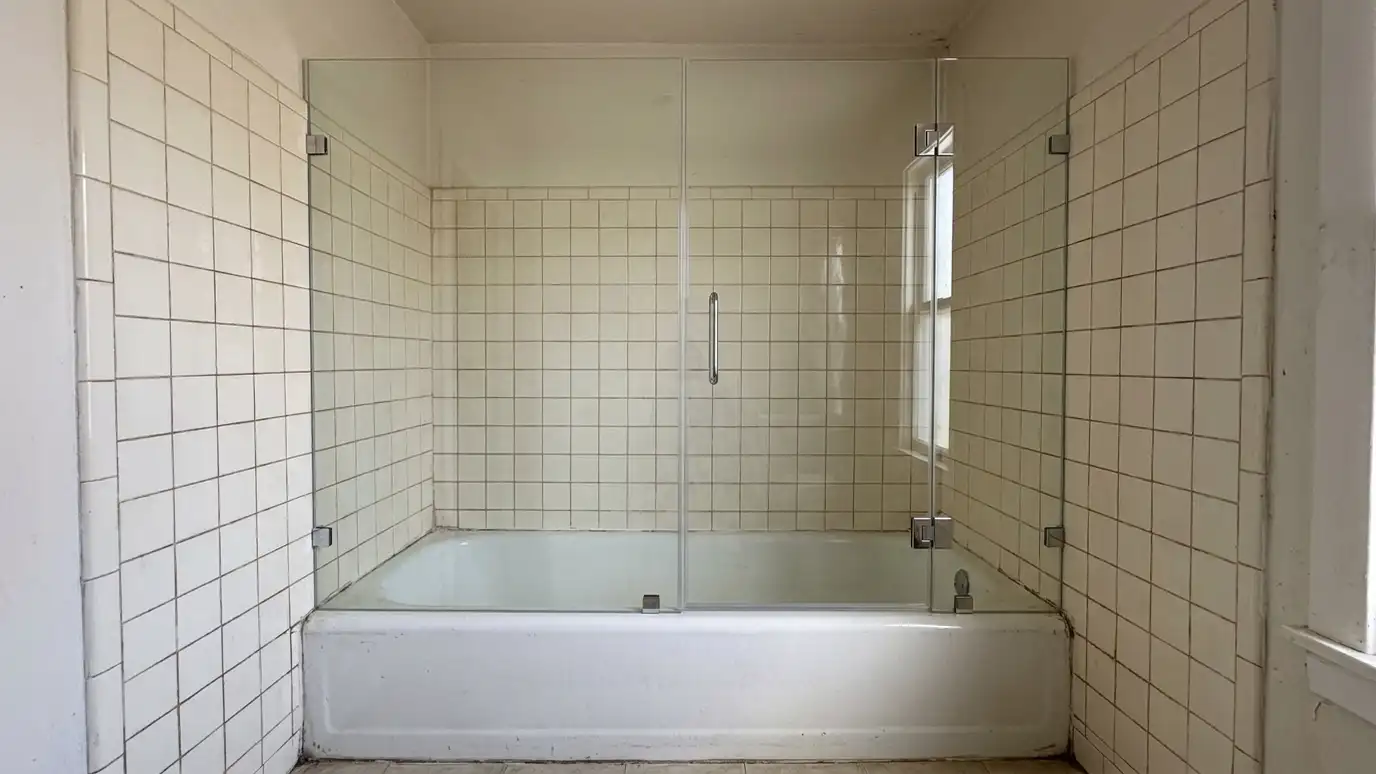 After: A plastic curtain replaced by frameless glass | Music City Shower Service After: a tub and shower with a clean glass shower enclosure with chrome hardware