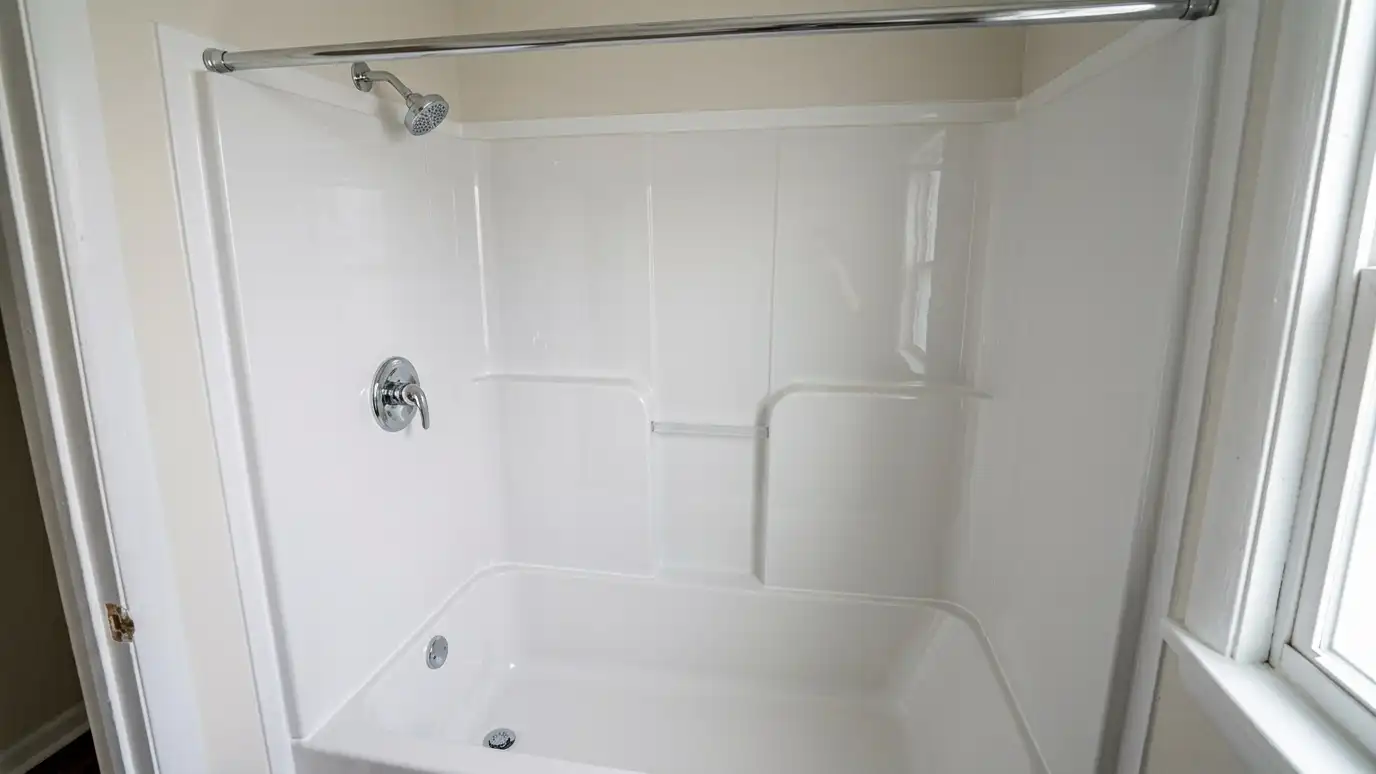 After: A yellowed fiberglass stall replaced | Music City Shower Service After: a small bathroom with a bright white acrylic shower with shining chrome fixtures
