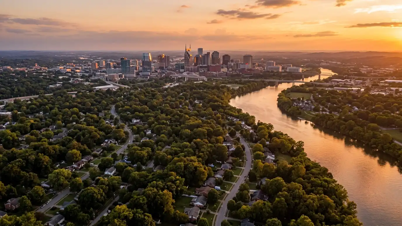 Shower service areas | Nashville and Middle Tennessee A golden sunset over a wide river winding past tree-covered suburban neighborhoods toward a distant downtown skyline